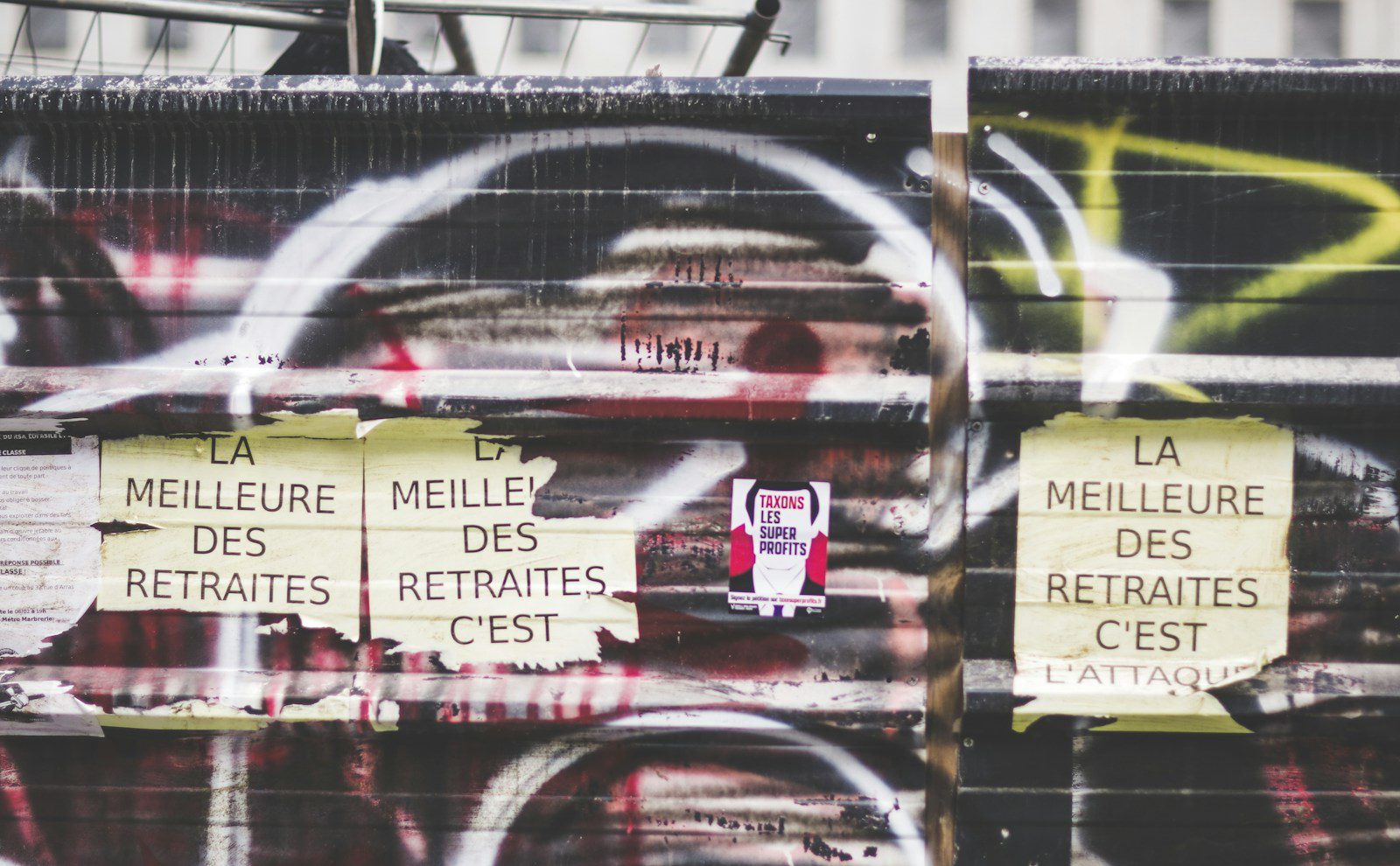 a bunch of signs on a wall covered in graffiti